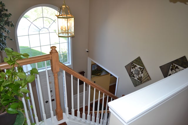 stairway featuring a chandelier