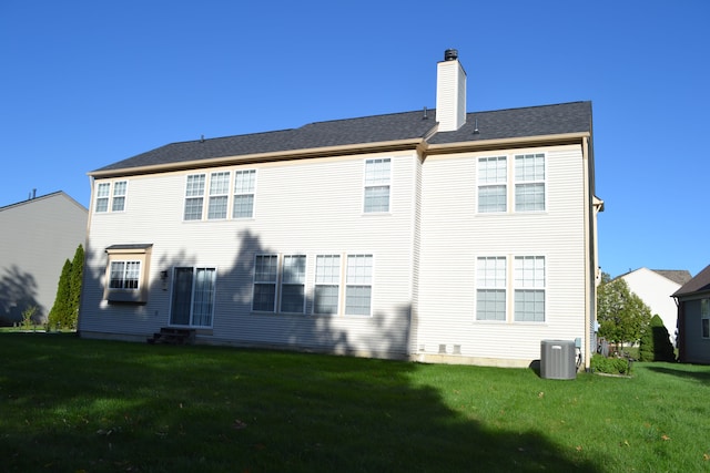 back of house featuring a lawn and cooling unit