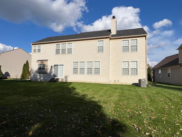 rear view of property featuring cooling unit and a lawn