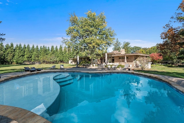 view of pool with a yard