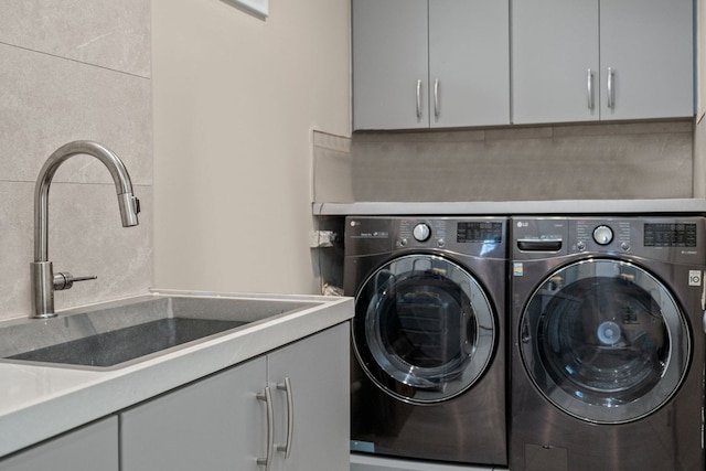 laundry room with cabinets, independent washer and dryer, and sink