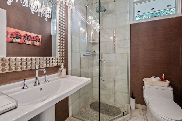 bathroom featuring toilet, a shower with door, and sink