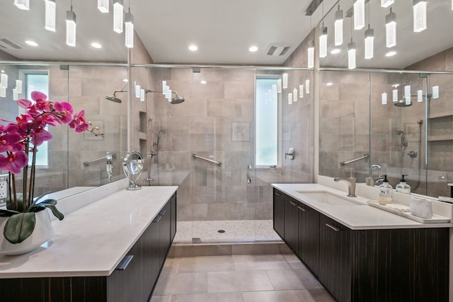 bathroom with walk in shower, vanity, and a wealth of natural light