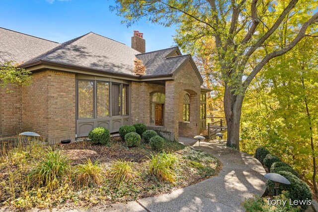 610 Cascade Hills Holw SE, Grand Rapids, MI 49546 - view of front of house with brick siding, a chimney, and roof with shingles