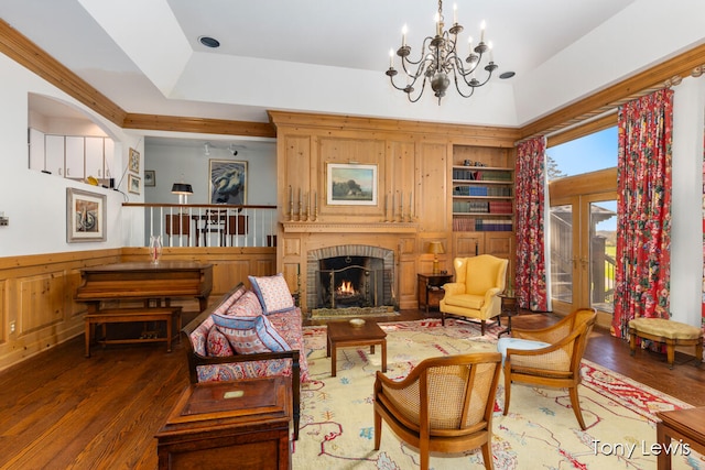 living room featuring a fireplace, french doors, dark hardwood / wood-style floors, and an inviting chandelier