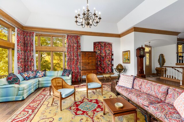 610 Cascade Hills Holw SE, Grand Rapids, MI 49546 - living room featuring a chandelier, wood finished floors, ornamental molding, arched walkways, and a raised ceiling
