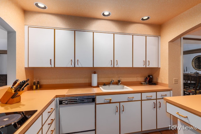 kitchen featuring white dishwasher, white cabinets, black electric cooktop, and sink