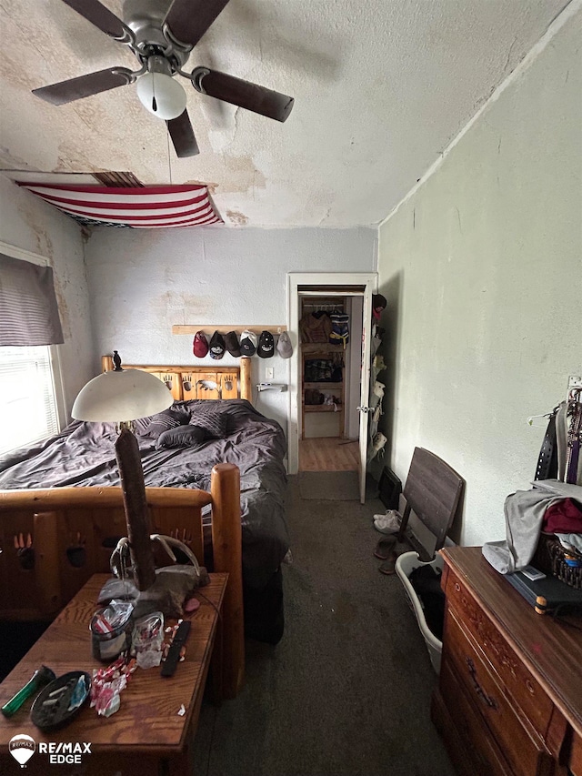 bedroom featuring ceiling fan, carpet, and a textured ceiling