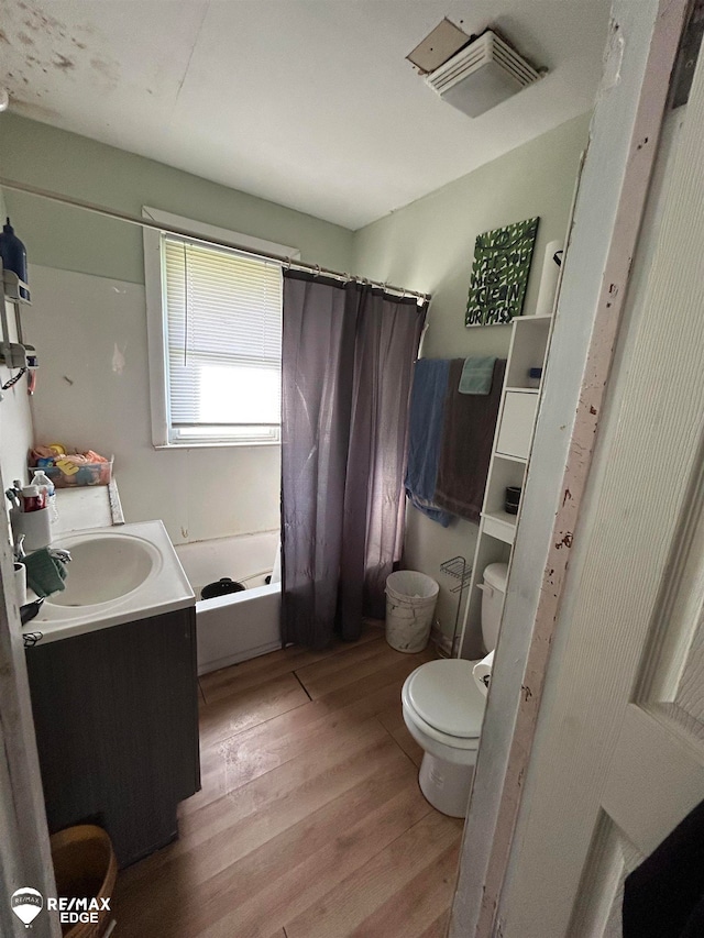 full bathroom with wood-type flooring, vanity, toilet, and shower / bathtub combination with curtain