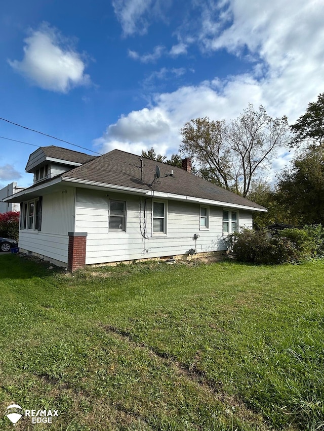 rear view of property featuring a lawn