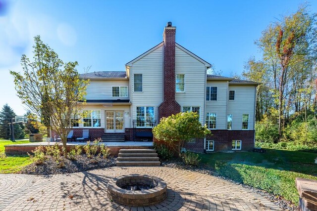 back of house featuring a yard and an outdoor fire pit