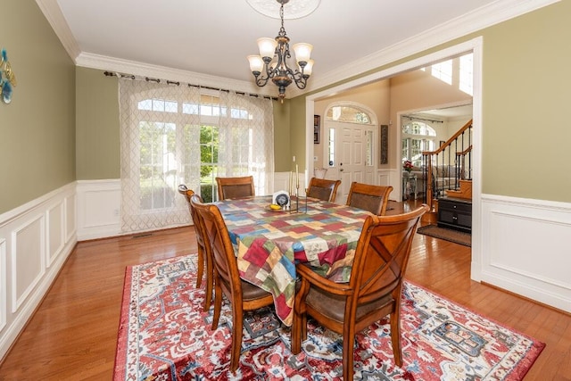 dining room featuring light hardwood / wood-style floors, crown molding, and a chandelier