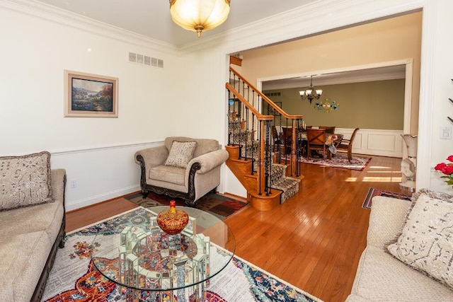 living room with a chandelier, hardwood / wood-style flooring, and crown molding