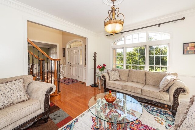 living room with wood-type flooring and ornamental molding