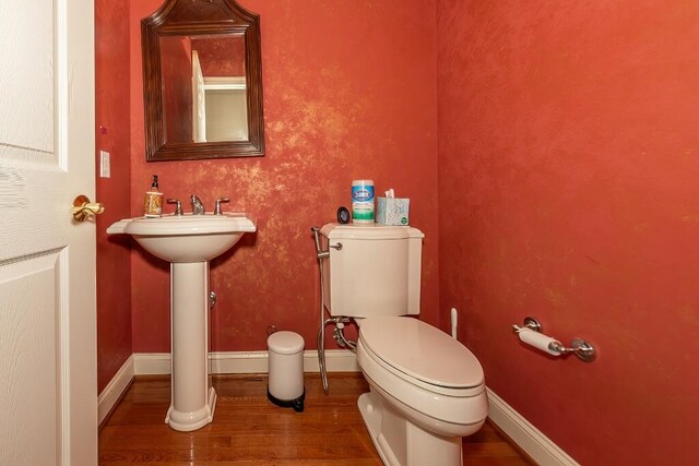 bathroom with toilet and wood-type flooring