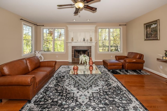 living room with a tile fireplace, ceiling fan, and hardwood / wood-style flooring