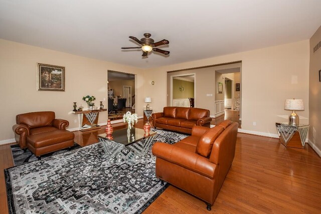 living room featuring hardwood / wood-style floors and ceiling fan