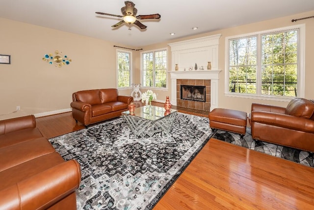 living room featuring a fireplace, hardwood / wood-style floors, and ceiling fan