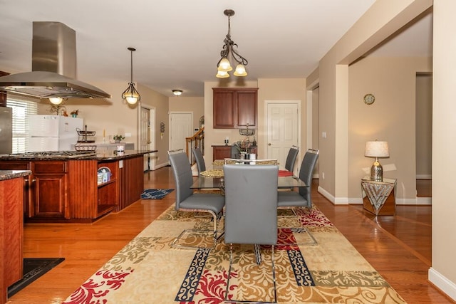 dining room with light hardwood / wood-style floors and a chandelier