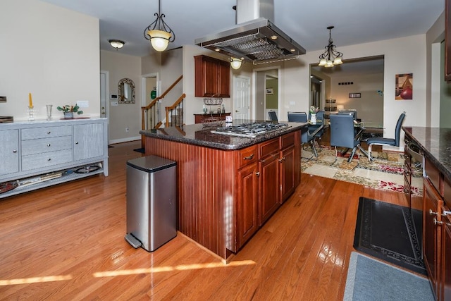 kitchen with island range hood, a kitchen island, pendant lighting, and light wood-type flooring