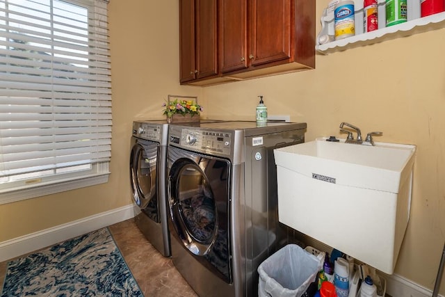 clothes washing area with cabinets, independent washer and dryer, and sink