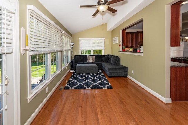 living room featuring hardwood / wood-style floors, ceiling fan, and lofted ceiling