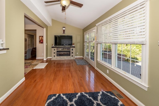 living room with ceiling fan, plenty of natural light, hardwood / wood-style floors, and vaulted ceiling