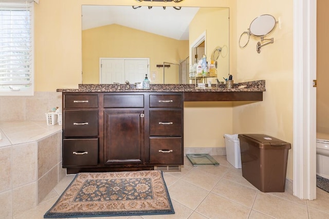 bathroom with tile patterned flooring, toilet, a wealth of natural light, and lofted ceiling