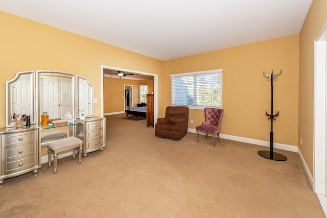 sitting room featuring light carpet and ceiling fan