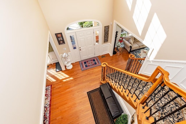 foyer entrance with wood-type flooring and a high ceiling