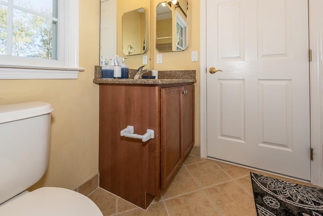 bathroom featuring tile patterned flooring, vanity, and toilet