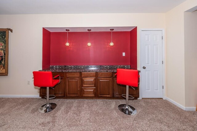 bar with light colored carpet and hanging light fixtures