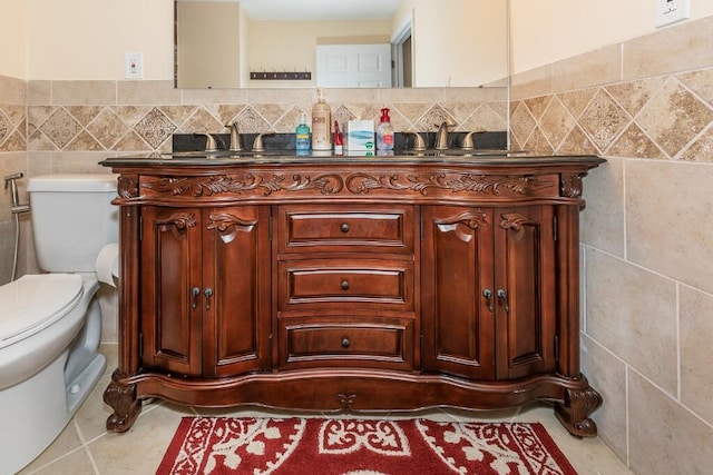 bathroom featuring tile patterned floors, vanity, toilet, and tile walls