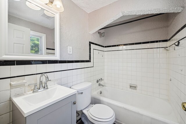 19789-19791 Meyers Rd, Detroit, MI 48235 - full bath featuring a textured wall, toilet, vanity, bathtub / shower combination, and tile walls
