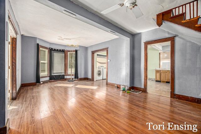 empty room featuring independent washer and dryer, ceiling fan, and hardwood / wood-style flooring