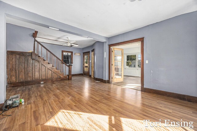 421 Lewis St, Belding, MI 48809 - unfurnished living room with stairs, wood finished floors, baseboards, and ceiling fan