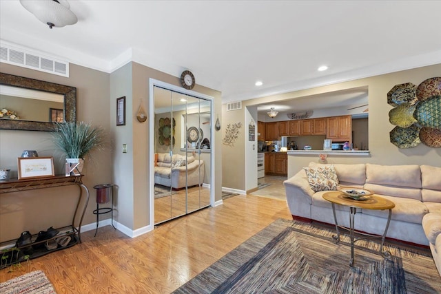 living room featuring ornamental molding and light hardwood / wood-style flooring