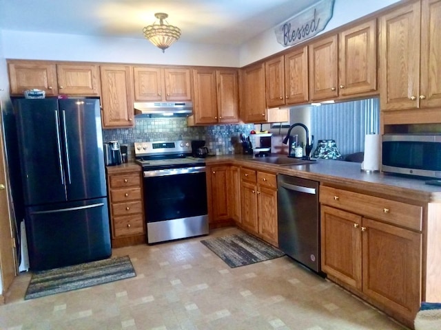 kitchen featuring appliances with stainless steel finishes, sink, and decorative backsplash