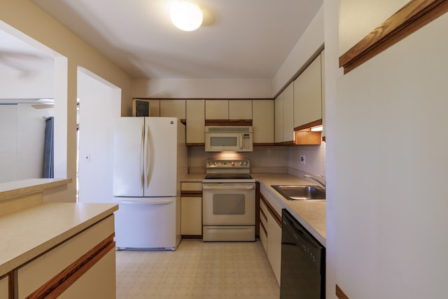 kitchen featuring cream cabinets, white appliances, tasteful backsplash, and sink