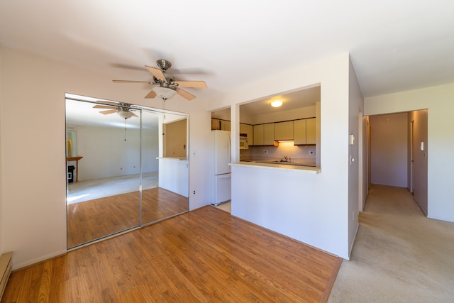 kitchen with ceiling fan, light hardwood / wood-style floors, white appliances, and a baseboard radiator