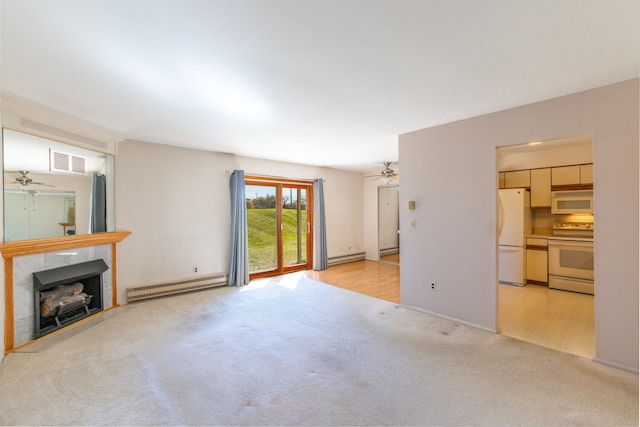 unfurnished living room featuring baseboard heating, a tiled fireplace, and light carpet