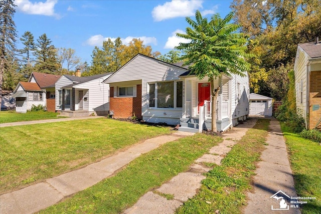 bungalow-style house with a garage, an outbuilding, and a front yard