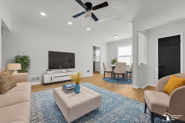 living room with light wood-type flooring and ceiling fan