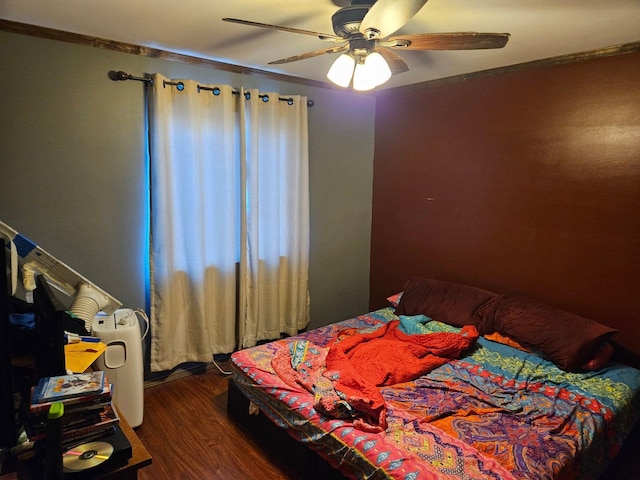 bedroom featuring ceiling fan, crown molding, and dark hardwood / wood-style floors