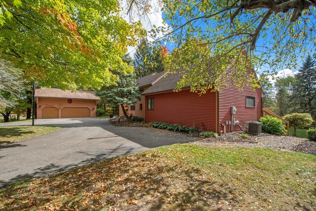 view of front of home featuring cooling unit and a garage