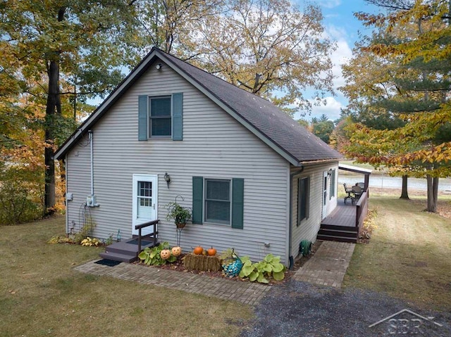 rear view of property featuring a lawn and a deck