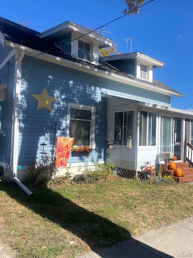 view of side of home with a yard and a sunroom