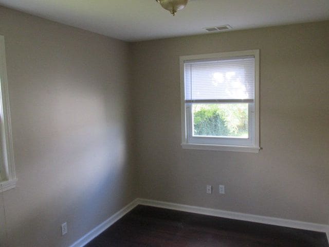 spare room featuring dark hardwood / wood-style flooring