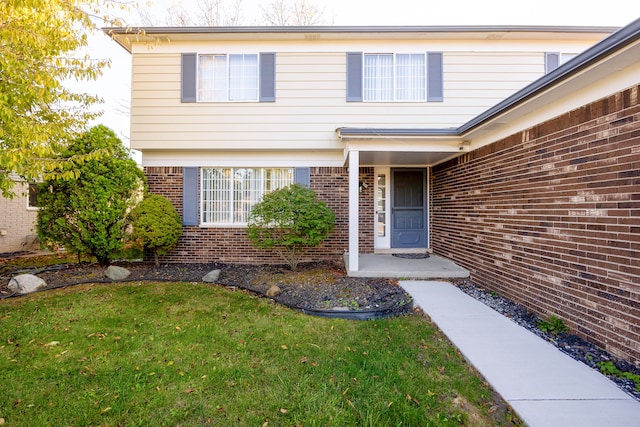 doorway to property with a lawn