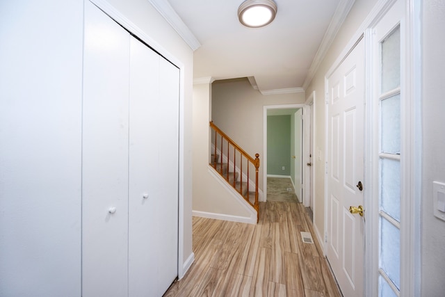 corridor with ornamental molding and light wood-type flooring